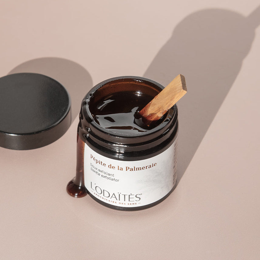 Doux exfoliant Pépite de la Palmeraie de L'Odaïtès avec le pot ouvert et de la texture qui coule sur le côté