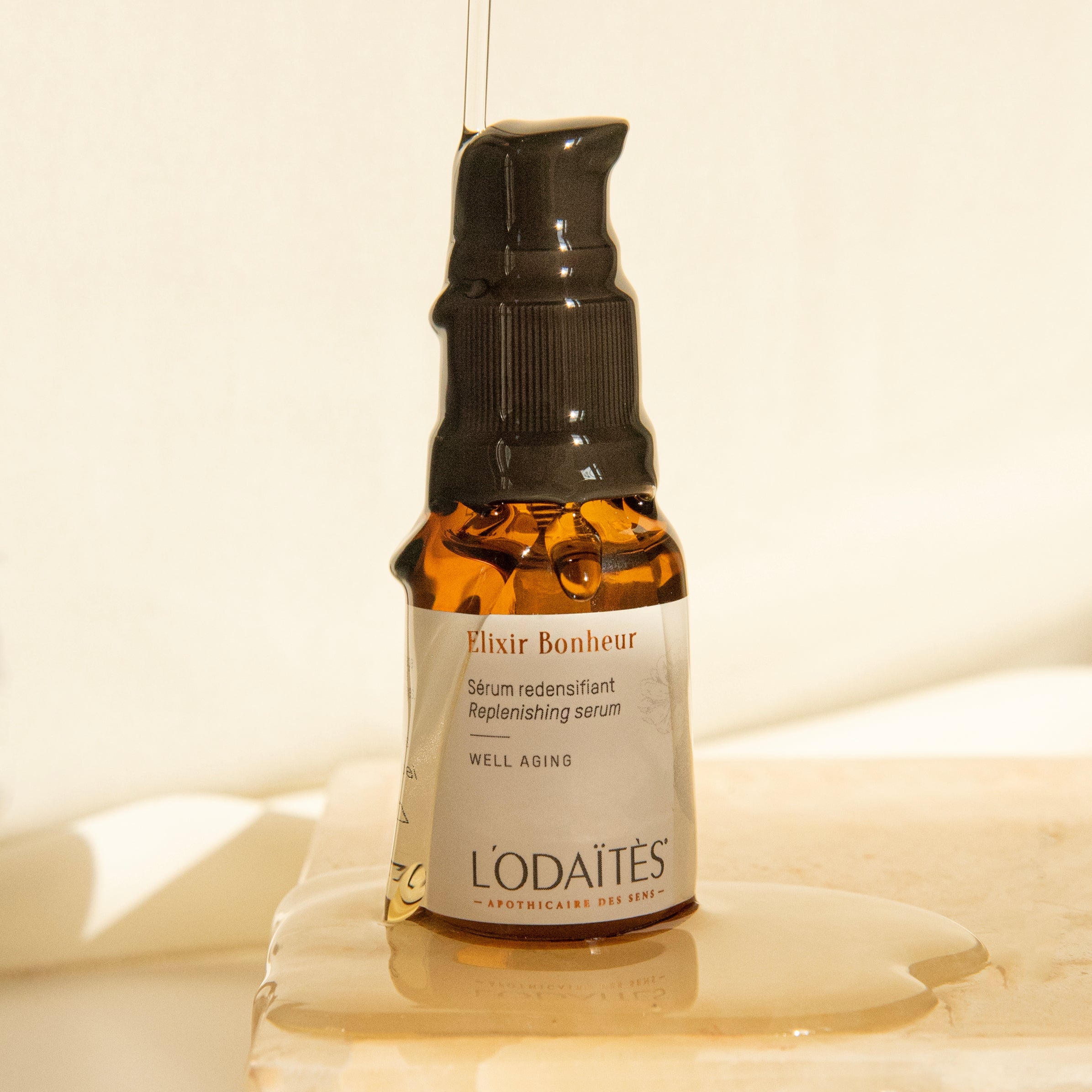 Sérum redensifiant Élixir Bonheur de L'Odaïtès avec la texture huileuse du sérum qui coule sur le flacon