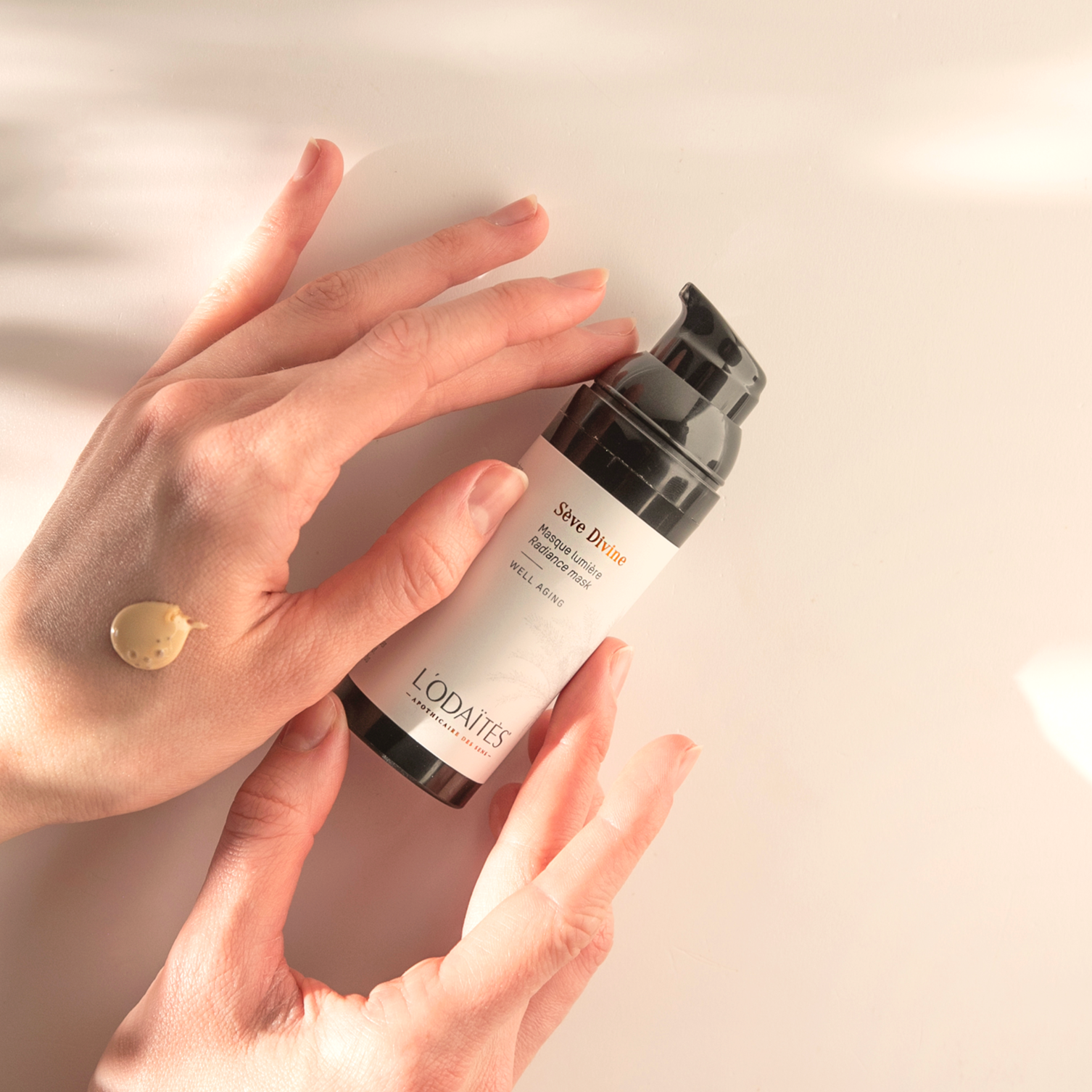 Masque lumière well-aging Sève Divine de L'Odaïtès tenu par deux mains avec de la texture sur l'une des deux mains
